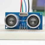 A picture showing green HC-SR04 ultrasonic sensor on breadbard